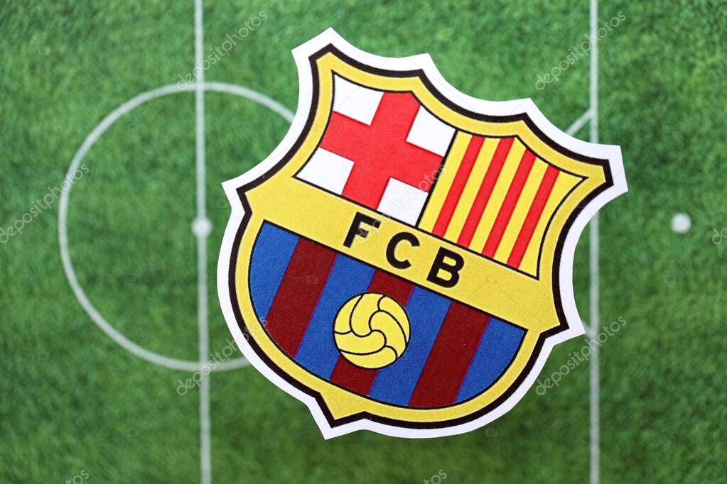 KYIV, UKRAINE - FEBRUARY 23, 2025 FC Barcelona football club badge lies on soccer field background banner