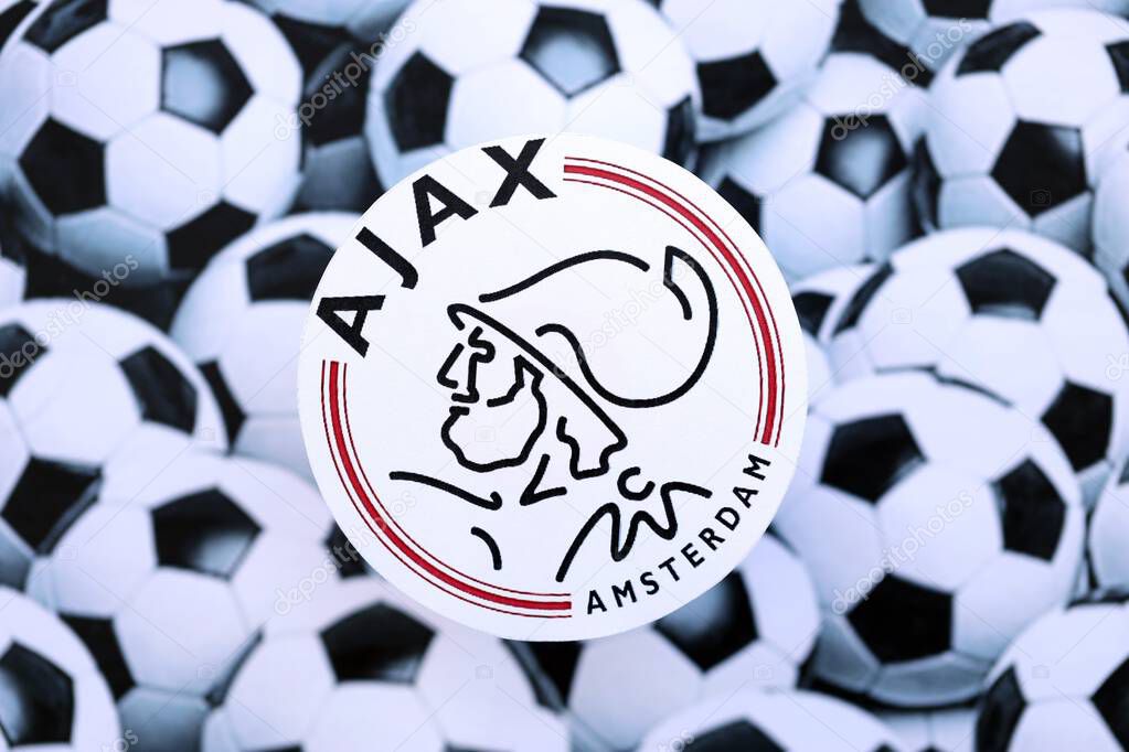 KYIV, UKRAINE - FEBRUARY 23, 2025 AFC Ajax football club badge lies on soccer balls background banner