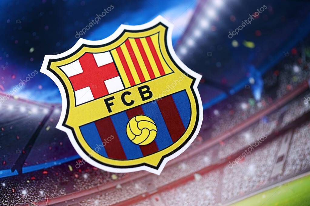 KYIV, UKRAINE - FEBRUARY 23, 2025 FC Barcelona football club badge lies on soccer stadium background banner