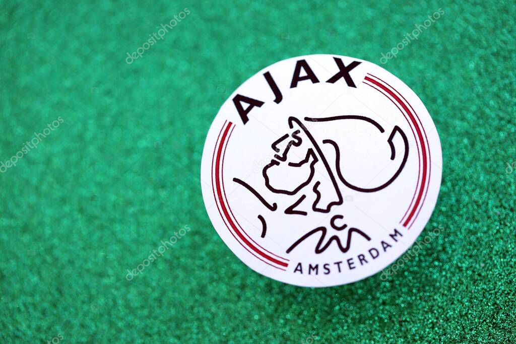 KYIV, UKRAINE - FEBRUARY 23, 2025 AFC Ajax football club badge lies on emerald green glitter background banner