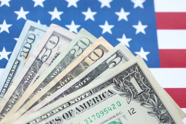 Amerikan doları banknotları ve Amerikan bayrağı kapanıyor. Para yatırımı konsepti ve vergi ödeme