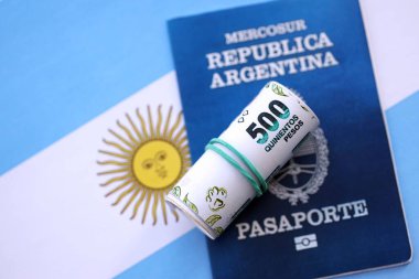 Arjantin pezosu büyük miktarda para ve pasaport Arjantin bayrağına yakın duruyor. Finans ve bankacılık kavramı