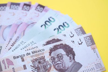 Meksika pezosu faturaları büyük miktarlarda sarı renkli masaya yakın duruyor. Finans ve bankacılık kavramı