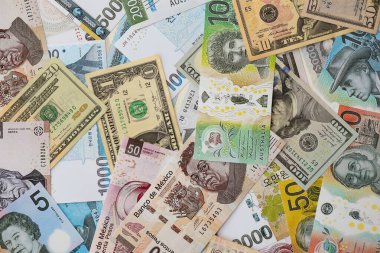 Farklı para birimlerinden ve ülkelerden yüklü miktarda para. Uluslararası nakitin çeşitli arka planında büyük bir yığın var.