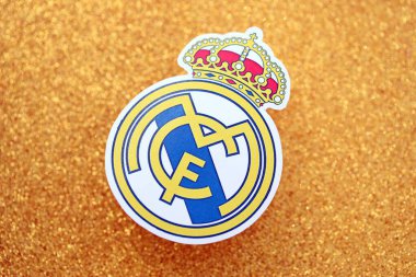 KYIV, UKRAINE - 23 Şubat 2025 Real Madrid CF futbol kulübü rozeti altın sarısı parıltılı arka plan pankartıyla uzanır