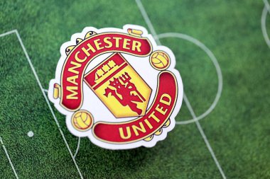 KYIV, UKRAINE - 23 Şubat 2025 Manchester United FC futbol kulübü rozeti futbol sahasının arka planında yer almaktadır