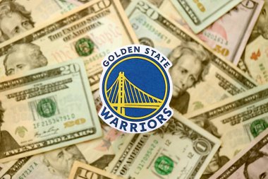 KYIV, UKRAINE - 23 Şubat 2025 Golden State Warriors basketbol takımı rozeti büyük miktarda Amerikan dolarının üzerinde.