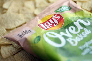 KYIV, UKRAINE - 19 Nisan 2025 Fırında fırında yoğurt ve yeşil patates cipsi ve Lays resmi logosu.