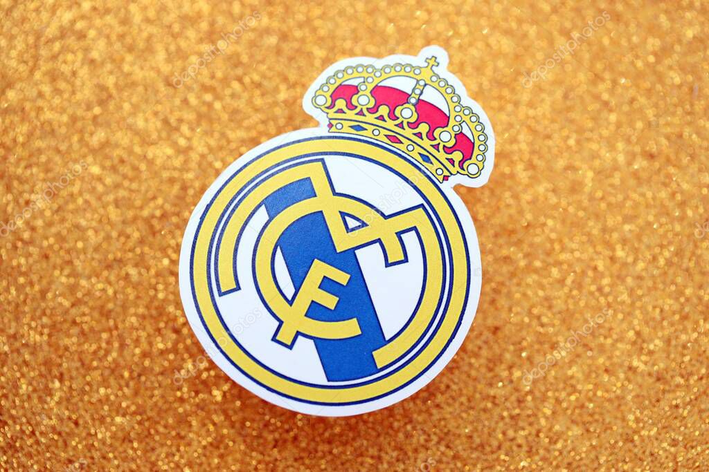KYIV, UKRAINE - FEBRUARY 23, 2025 Real Madrid CF football club badge lies on golden yellow glitter background banner