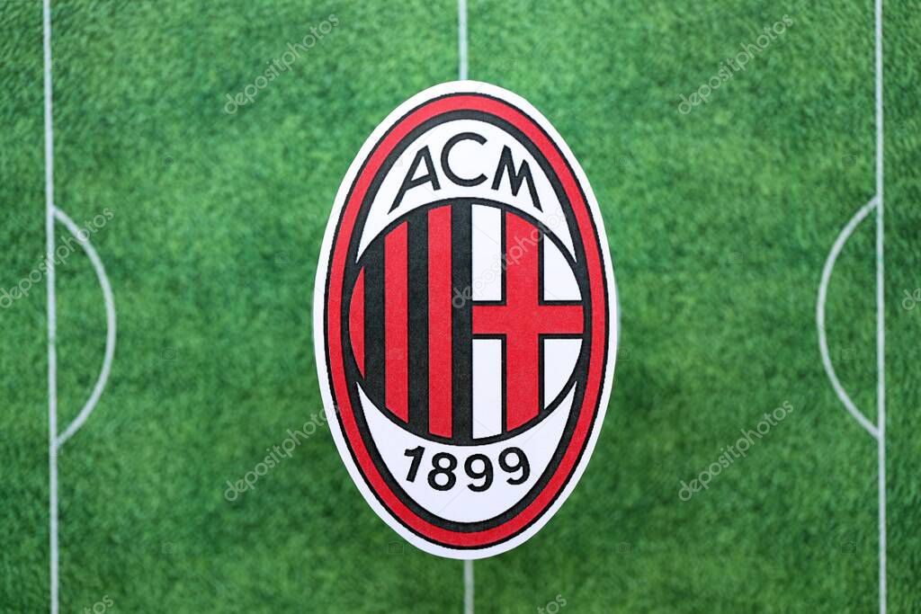 KYIV, UKRAINE - FEBRUARY 23, 2025 AC Milan football club badge lies on soccer field background banner