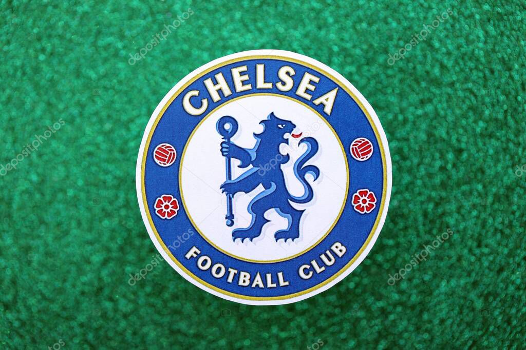 KYIV, UKRAINE - FEBRUARY 23, 2025 Chelsea FC football club badge lies on emerald green glitter background banner