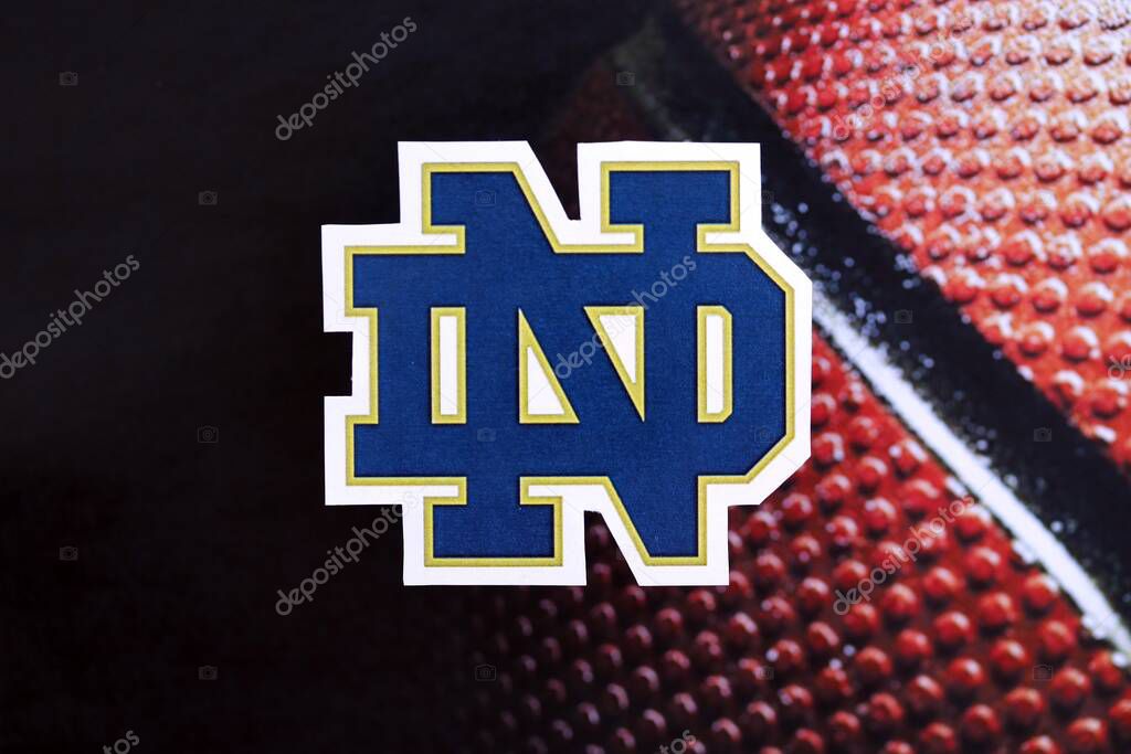 KYIV, UKRAINE - FEBRUARY 23, 2025 Notre Dame Fighting Irish basketball team badge lies on basketball ball background banner