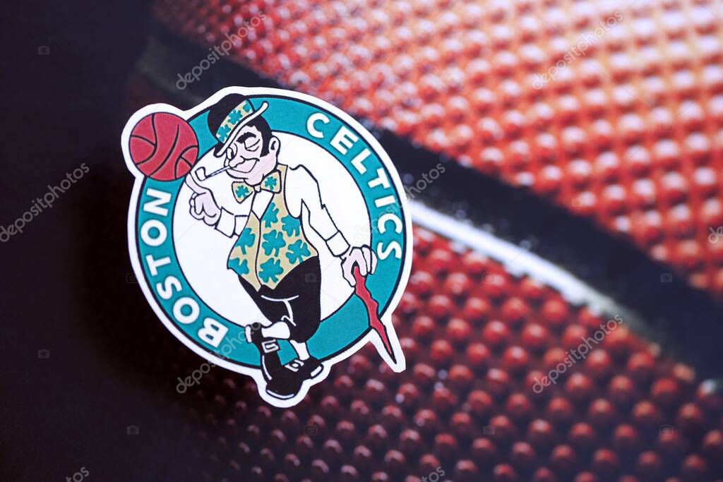 KYIV, UKRAINE - FEBRUARY 23, 2025 Boston Celtics basketball team badge lies on basketball ball background banner