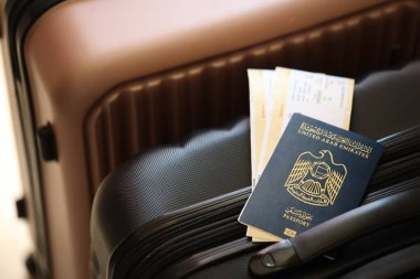 Biletli Birleşik Arap Emirlikleri pasaportu havaalanındaki bekleme salonunun yakınındaki turistik bavulda yatıyor. Dünya çapında seyahat ve uluslararası turizm kavramı