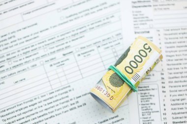 Güney Kore büyük miktarlarda para kazandı. Masada vergi formları var. Muhasebe ve vergilendirme kavramı