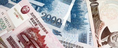 Kuzey Kore büyük miktarlarda para kazandı. Beyaz renkli masada yatıyor. Yakın plan. Finans ve bankacılık kavramı