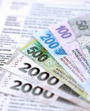 Arjantin pezosu büyük miktarlarda para masasında duruyor. Kalem ve vergi formları da yakında. Finans ve bankacılık kavramı