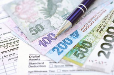 Arjantin pezosu büyük miktarlarda para masasında duruyor. Kalem ve vergi formları da yakında. Finans ve bankacılık kavramı