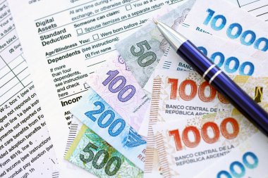 Arjantin pezosu büyük miktarlarda para masasında duruyor. Kalem ve vergi formları da yakında. Finans ve bankacılık kavramı