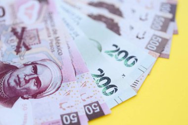Meksika pezosu faturaları büyük miktarlarda sarı renkli masaya yakın duruyor. Finans ve bankacılık kavramı