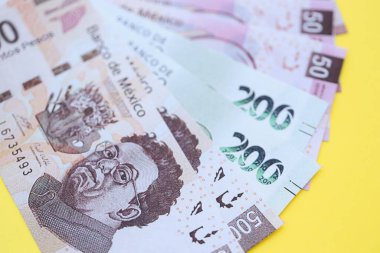 Meksika pezosu faturaları büyük miktarlarda sarı renkli masaya yakın duruyor. Finans ve bankacılık kavramı