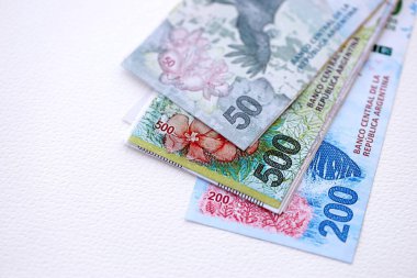Arjantin pezosu büyük miktarlarda para beyaz masada yakın planda yatıyor. Finans ve bankacılık kavramı