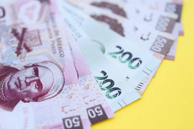 Meksika pezosu faturaları büyük miktarlarda sarı renkli masaya yakın duruyor. Finans ve bankacılık kavramı
