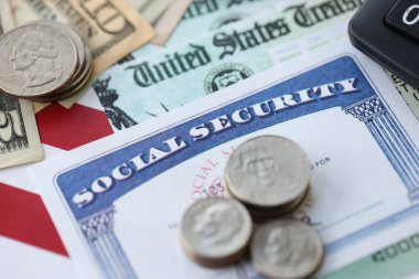 Amerikan doları para faturaları, sosyal güvenlik numarası ve Amerikan bayrağındaki hesap makinesi yakın plan. Vergi ödeme ve sigorta kavramı