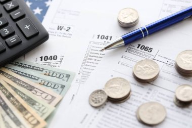 Amerikan Doları. Para banknotları ve vergi formundaki kalem ve hesap makineli paralar boş. Muhasebe ve vergi ödeme dönemi kavramı