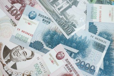 Kuzey Kore büyük miktarlarda para kazandı. Beyaz renkli masada yatıyor. Yakın plan. Finans ve bankacılık kavramı