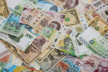 Farklı para birimlerinden ve ülkelerden yüklü miktarda para. Uluslararası nakitin çeşitli arka planında büyük bir yığın var.