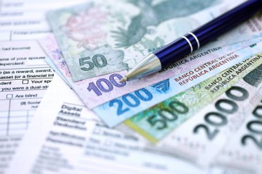 Arjantin pezosu büyük miktarlarda para masasında duruyor. Kalem ve vergi formları da yakında. Finans ve bankacılık kavramı