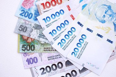 Arjantin pezosu büyük miktarlarda para beyaz masada yakın planda yatıyor. Finans ve bankacılık kavramı