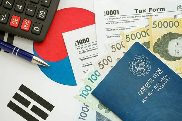 Güney Kore büyük miktarda para kazandı. Masada kalem, hesap makinesi, pasaport ve vergi formları var. Vergi ödeme ve muhasebe kavramı
