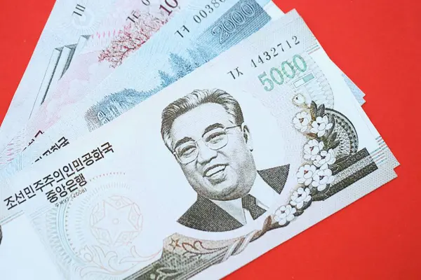 Kuzey Kore büyük miktarlarda para kazandı. Yakın plan kırmızı masada yatıyor. Finans ve bankacılık kavramı