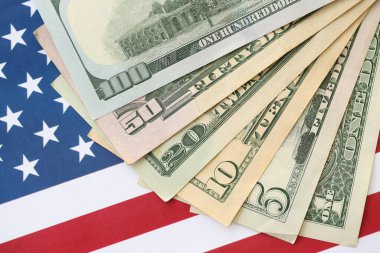 Amerikan doları banknotları ve Amerikan bayrağı kapanıyor. Para yatırımı konsepti ve vergi ödeme