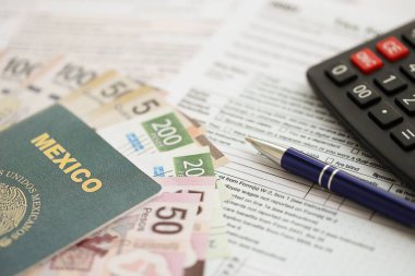 Meksika pezosu para faturaları kalem, hesap makinesi, pasaport ve vergi formlarıyla dolu. Finans ve bankacılık kavramı