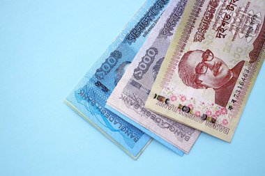 Bangladeşli para banknotları büyük miktarlarda deniz mavisi renkli masaların üzerinde. Finans ve bankacılık kavramı