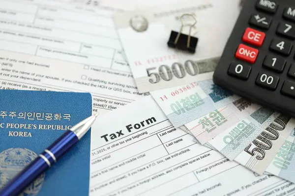 Kuzey Kore büyük miktarlarda para kazandı. Masada kalem, hesap makinesi, pasaport ve vergi formları var. Vergi ödeme ve muhasebe kavramı
