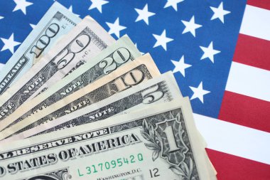 Amerikan doları banknotları ve Amerikan bayrağı kapanıyor. Para yatırımı konsepti ve vergi ödeme