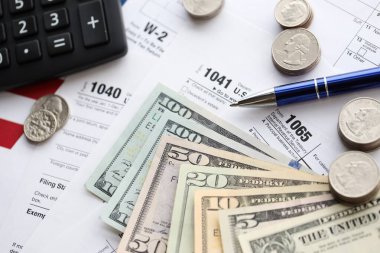 Amerikan Doları. Para banknotları ve vergi formundaki kalem ve hesap makineli paralar boş. Muhasebe ve vergi ödeme dönemi kavramı