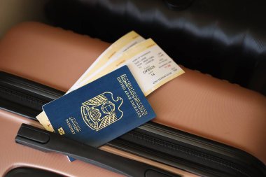 Biletli Birleşik Arap Emirlikleri pasaportu havaalanındaki bekleme salonunun yakınındaki turistik bavulda yatıyor. Dünya çapında seyahat ve uluslararası turizm kavramı