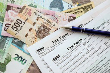 Değişik para birimlerinden ve ülkelerden oluşan büyük miktarlarda para ve vergi beyannamesi doldurulmaya hazır. Uluslararası nakitin çeşitli arka planında büyük bir yığın var.