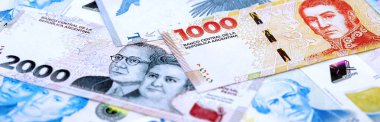 Arjantin pezosu büyük miktarlarda para beyaz masada yakın planda yatıyor. Finans ve bankacılık kavramı