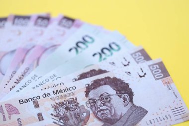 Meksika pezosu faturaları büyük miktarlarda sarı renkli masaya yakın duruyor. Finans ve bankacılık kavramı