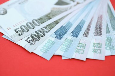 Kuzey Kore büyük miktarlarda para kazandı. Yakın plan kırmızı masada yatıyor. Finans ve bankacılık kavramı