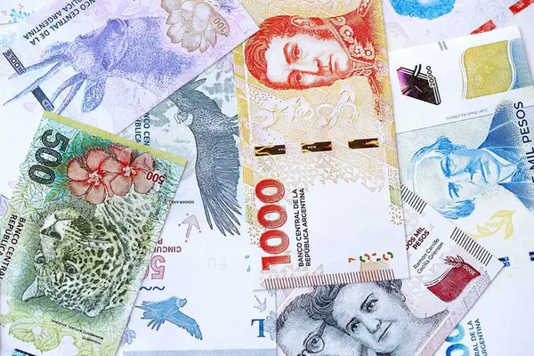 Arjantin pezosu büyük miktarlarda para beyaz masada yakın planda yatıyor. Finans ve bankacılık kavramı