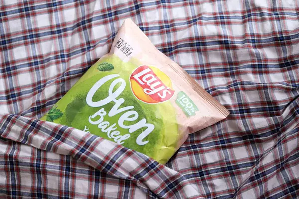KYIV, UKRAINE - 19 Nisan 2025 Fırında fırında yoğurt ve yeşil patates cipsi ve Lays resmi logosu.