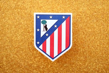 KYIV, UKRAINE - 23 Şubat 2025 Atletico de Madrid futbol kulübü rozeti altın sarısı parıltılı arka plan pankartıyla uzanır