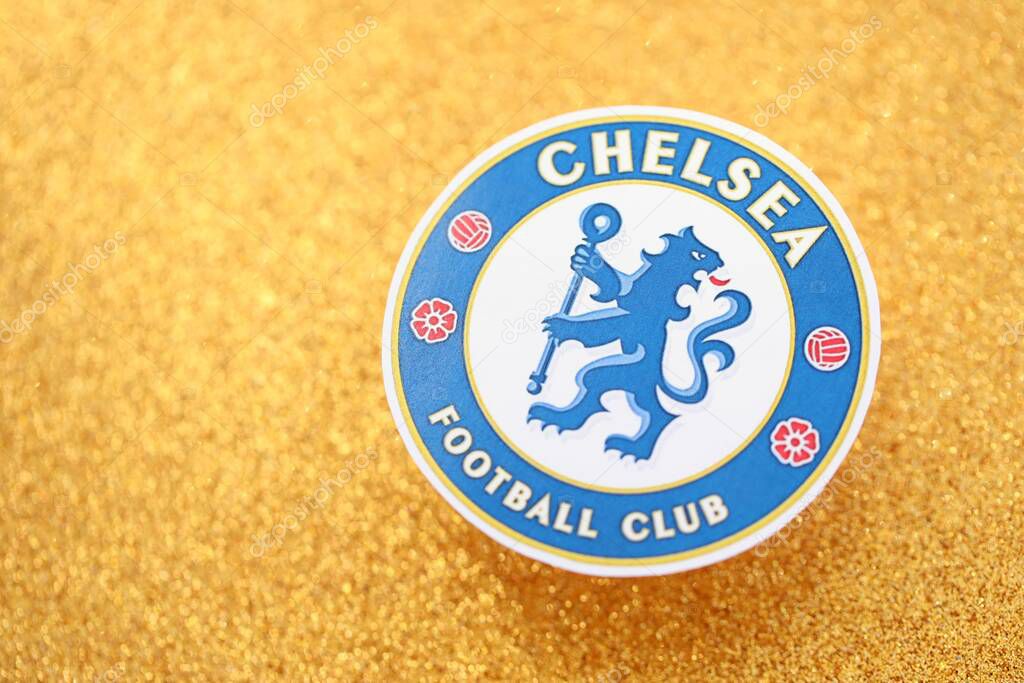 KYIV, UKRAINE - FEBRUARY 23, 2025 Chelsea FC football club badge lies on golden yellow glitter background banner